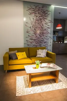a living room with a yellow couch and a coffee table at MOCHA HOUSE 3 ROOM CENTRAL APARTMENT 56d in Kaunas