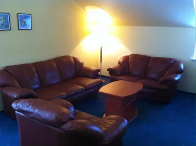 a living room with two leather couches and a lamp at Guest House Guba in Molėtai