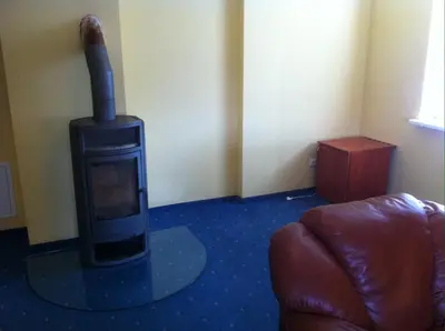 a living room with a wood stove in a room at Guest House Guba in Molėtai