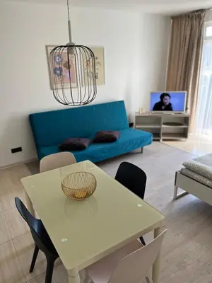a living room with a table and a blue couch at Near Station Apartment in Vilnius