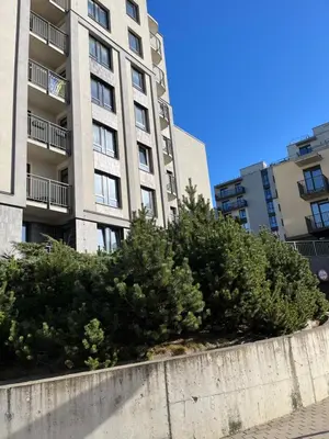 a concrete retaining wall with bushes in front of a building at Near Station Apartment in Vilnius
