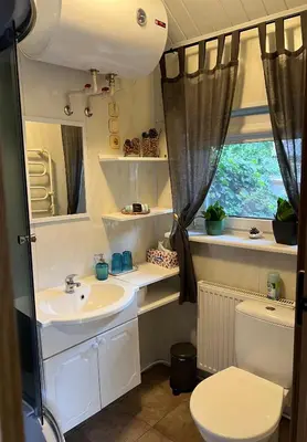 a bathroom with a sink and a toilet and a window at Center studio hause in Kaunas
