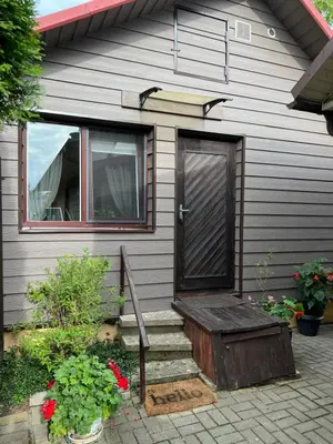 a house with a wooden door and some flowers at Center studio hause in Kaunas