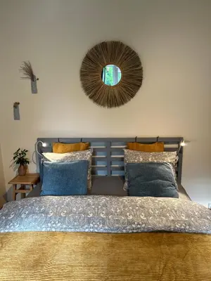 a bedroom with a bed with a mirror on the wall at Center studio hause in Kaunas