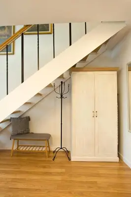 a living room with a bench and a staircase at Relax Birstonas in Birštonas