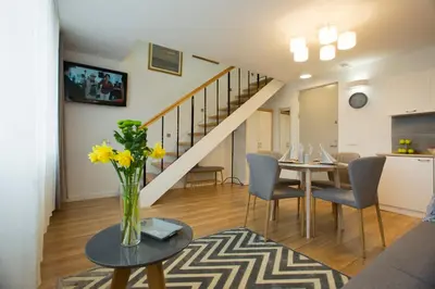 a living room with a table with a vase of flowers at Relax Birstonas in Birštonas