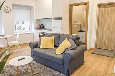 a living room with a couch and a kitchen at Modern 1BD Apartment in Old Town by Hostlovers in Kaunas