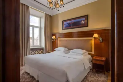 a bedroom with a large white bed and a window at Grand Hotel Vilnius, Curio Collection by Hilton in Vilnius