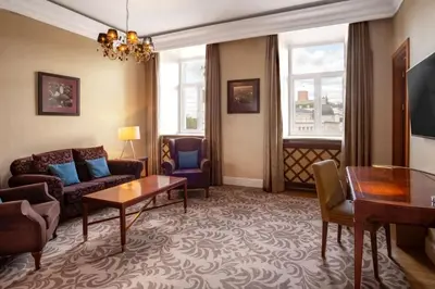 a living room with a couch and a table at Grand Hotel Vilnius, Curio Collection by Hilton in Vilnius