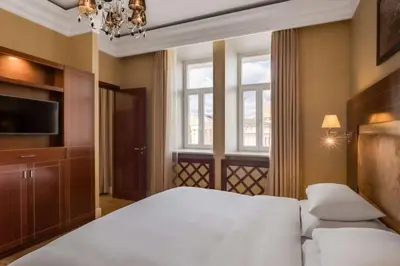 a bedroom with a white bed and a window at Grand Hotel Vilnius, Curio Collection by Hilton in Vilnius