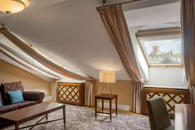 a living room with a couch and a table and a window at Grand Hotel Vilnius, Curio Collection by Hilton in Vilnius