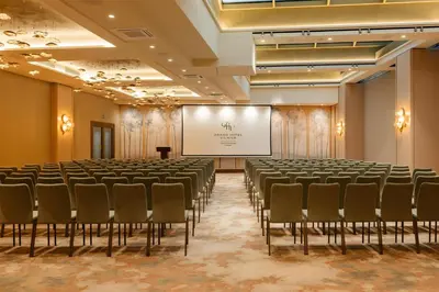 a lecture hall with chairs and a projection screen at Grand Hotel Vilnius, Curio Collection by Hilton in Vilnius