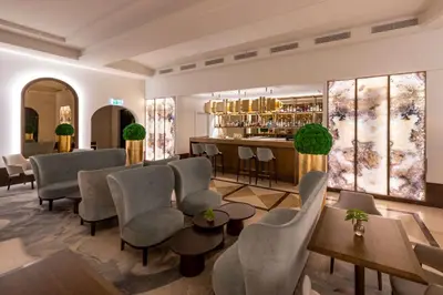 a lobby of a hotel with chairs and a bar at Grand Hotel Vilnius, Curio Collection by Hilton in Vilnius
