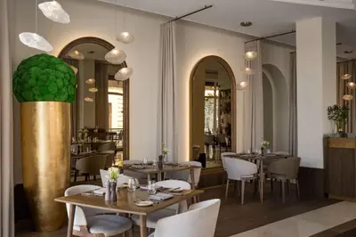 a restaurant with tables and chairs in a room at Grand Hotel Vilnius, Curio Collection by Hilton in Vilnius