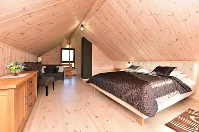 a bedroom with a bed and a desk and a chair at Vip Forest dreams villa in Anykščiai