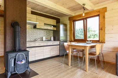 a kitchen with a wood stove and a table at Vip Forest dreams villa in Anykščiai