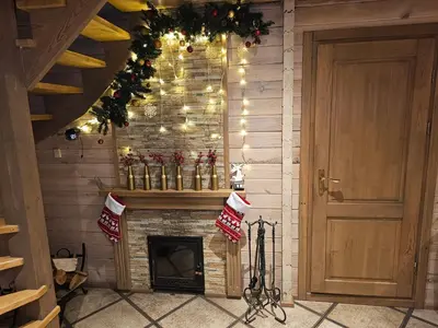 a living room with a fireplace and christmas decorations at Holiday House & Sauna in Druskininkai in Neravai