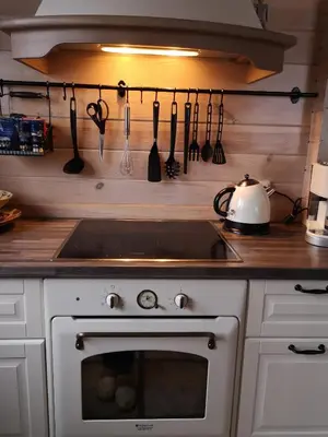 a kitchen with a stove and utensils on the wall at Holiday House & Sauna in Druskininkai in Neravai