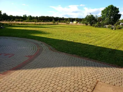 a brick walkway next to a field of grass at Holiday House & Sauna in Druskininkai in Neravai
