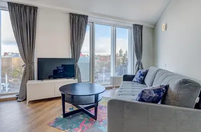 a living room with a couch and a table and windows at City View Apartment 57 in Vilnius
