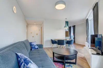 a living room with a blue couch and a table at City View Apartment 57 in Vilnius