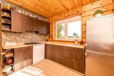 a kitchen with wooden cabinets and a refrigerator at Edmart in Dobromislė