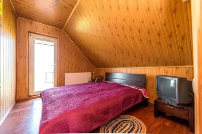 a bedroom with a bed and a tv at Edmart in Dobromislė