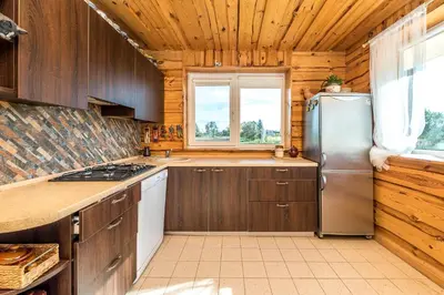 a kitchen with wooden cabinets and a stainless steel refrigerator at Edmart in Dobromislė