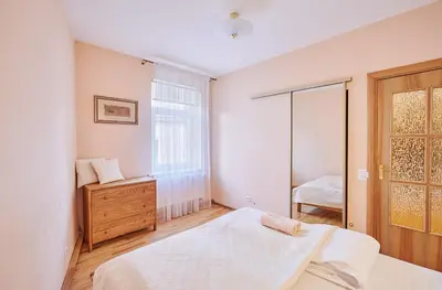 a white bedroom with a bed and a window at Kurpių gatvė in Kaunas