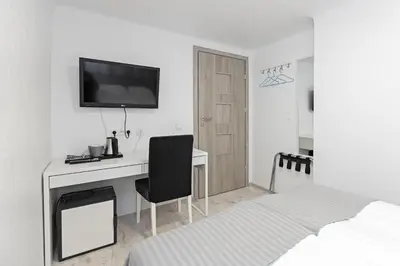 a bedroom with a desk and a bed and a television at HappyInn Rooms in Kaunas