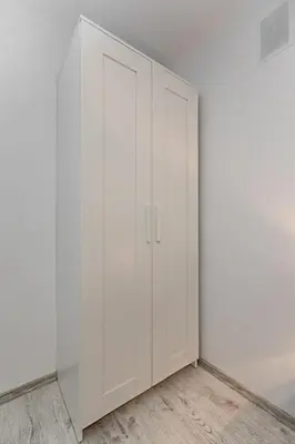 a white cabinet in the corner of a room at HappyInn Rooms in Kaunas