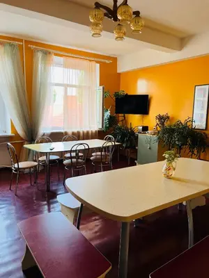 a room with tables and chairs and a tv at Apgyvendinimo įstaiga KORNEALITA-ZARASAI in Zarasai