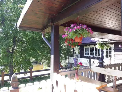 a wooden pergola with a table and flowers on it at Sodyba 