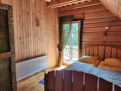a bedroom with a bed in a wooden room at Sodyba 