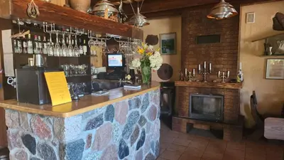 a bar with a vase of flowers and a fireplace at Sodyba 