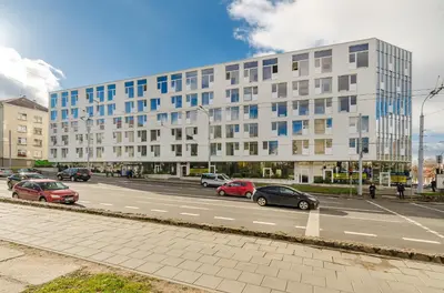 a street with cars parked in front of a large building at City Studio 1B in a great location in Vilnius