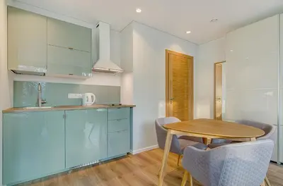 a kitchen with blue cabinets and a wooden table at City Studio 1A - Courtyard View in Vilnius