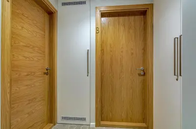 a corridor with two wooden doors in a room at City Studio 1A - Courtyard View in Vilnius