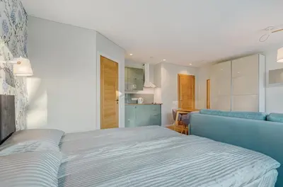 a bedroom with a bed and a blue couch at City Studio 1A - Courtyard View in Vilnius