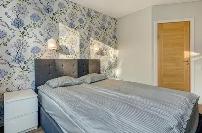 a bedroom with a bed with blue and white wallpaper at City Studio 1A - Courtyard View in Vilnius