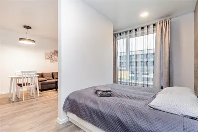 a white bedroom with a bed and a window at Apartments Vilnius 1 near center with a roof terrace and parking in Vilnius