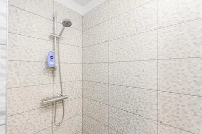 a shower with a blue shower head in a bathroom at Apartments Vilnius 1 near center with a roof terrace and parking in Vilnius