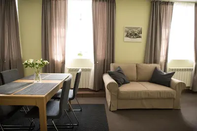 a living room with a table and a couch at Eliksyras Apartment in Vilnius