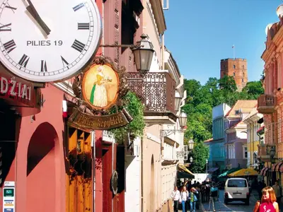 a clock on the side of a building with a street at Eliksyras Apartment in Vilnius