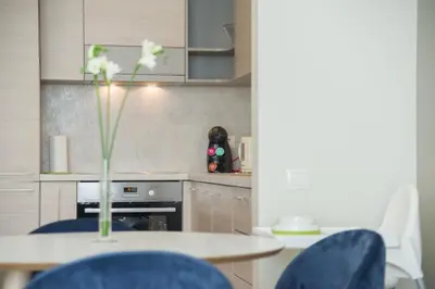 a kitchen with a table and a vase with flowers at Asian Magnolia Boutique Apartments in Druskininkai