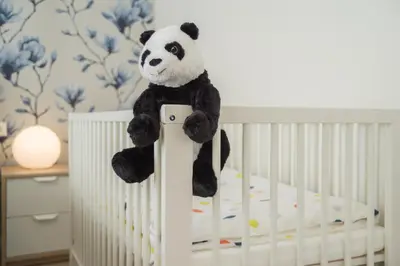 a stuffed panda bear sitting on top of a crib at Asian Magnolia Boutique Apartments in Druskininkai