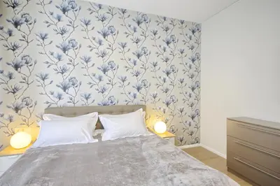 a bedroom with a bed with blue floral wallpaper at Asian Magnolia Boutique Apartments in Druskininkai