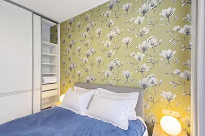 a bedroom with a bed with white flowers on the wall at Asian Magnolia Boutique Apartments in Druskininkai