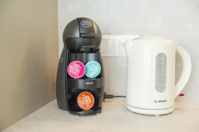 a black coffee maker sitting next to a white coffeemaker at Asian Magnolia Boutique Apartments in Druskininkai