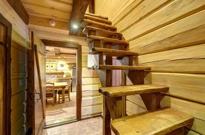 a log cabin with a wooden staircase in a room at Prie Klykio in Utena
